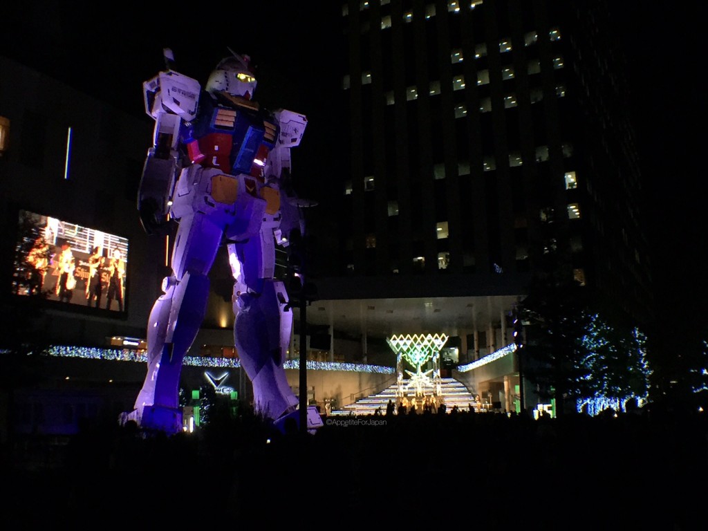 J-Pop band playing under Gundam statue